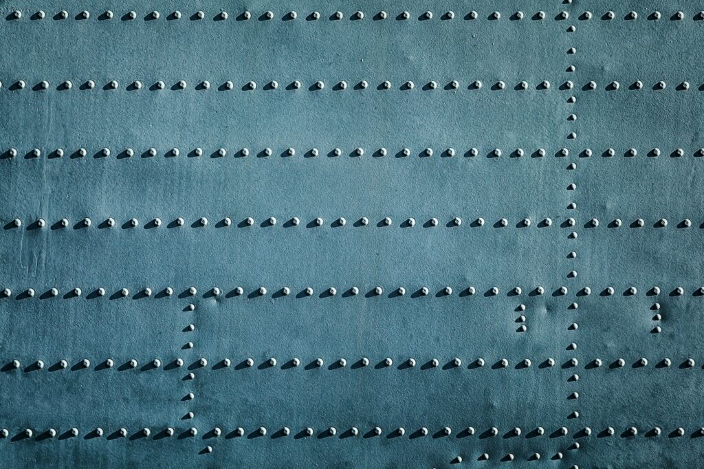 Grunge industrial background. Old painted metal with rivets